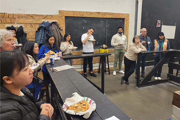 Attendees enjoying their pizza before axe throwing