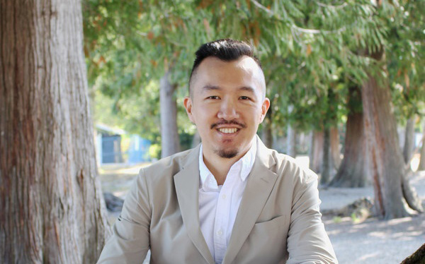 Laurence Ling standing in front of trees