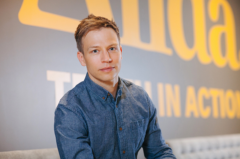 Jeff Wasyliw's headshot, taken in the lobby of Alida's offices, with Alida written on the wall behind Jeff