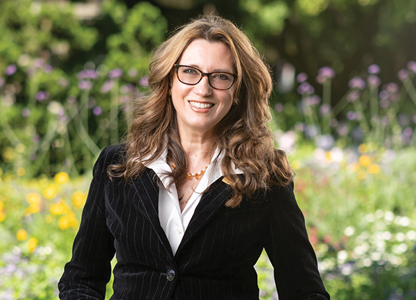 Karen Horcher, F C P A, F C G A, C F A, CPABC Board Chair, stands in front of a crop of wildflowers in the Stanley Park Rose Garden in Vancouver