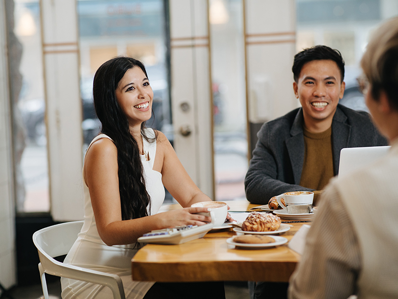 Karina Pangilinan,  Tony Huynh, and Frederick Wong enjoying coffee and treats while gathered at a table in a cafe