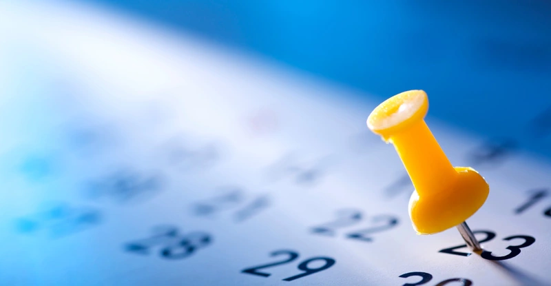 Yellow pushpin in a calendar on the 23th of a month 