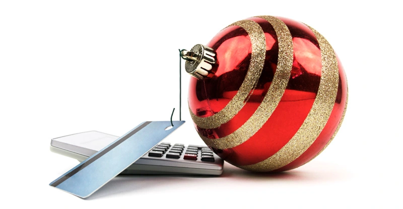 Stacked Credit Cards On Calculator with a Holiday Tree Ball