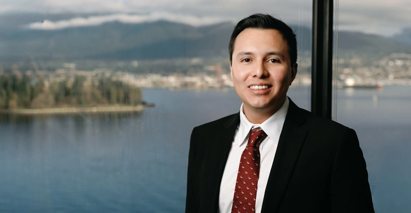 Image of Edgar Valaguez in front of an office window looking out over the inlet