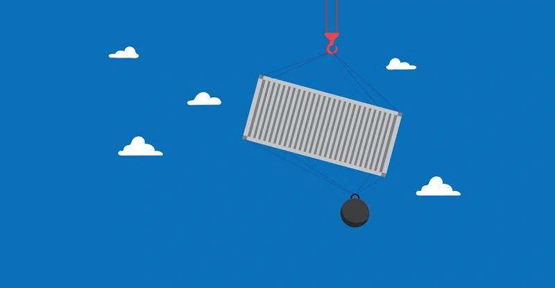 Shipping container lifted into the air with a giant weight attached to the bottom