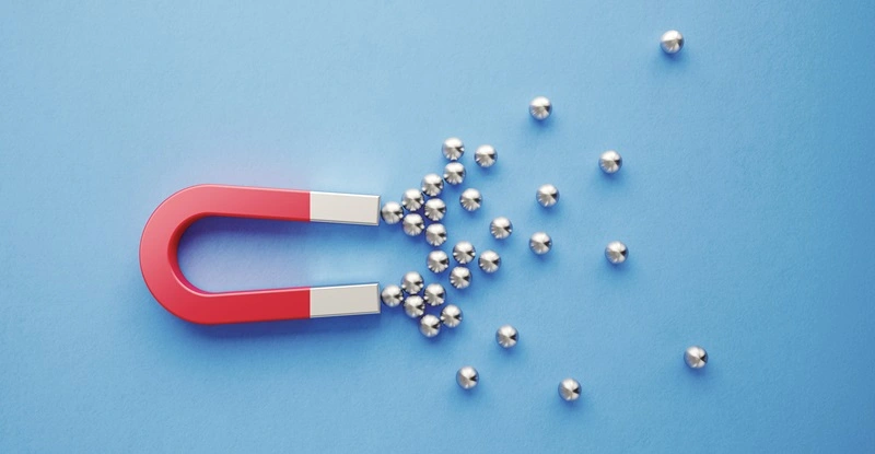 Silver Spheres Gravitated Towards a Red Magnet on Blue Background