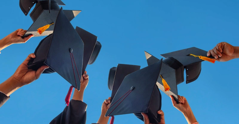 Low Angle View Of People Holding Cap Against Clear Sky